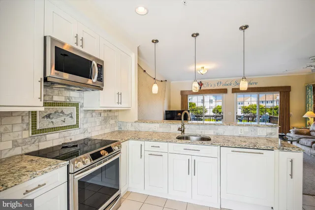 a kitchen with stainless steel appliances white cabinets stove and sink