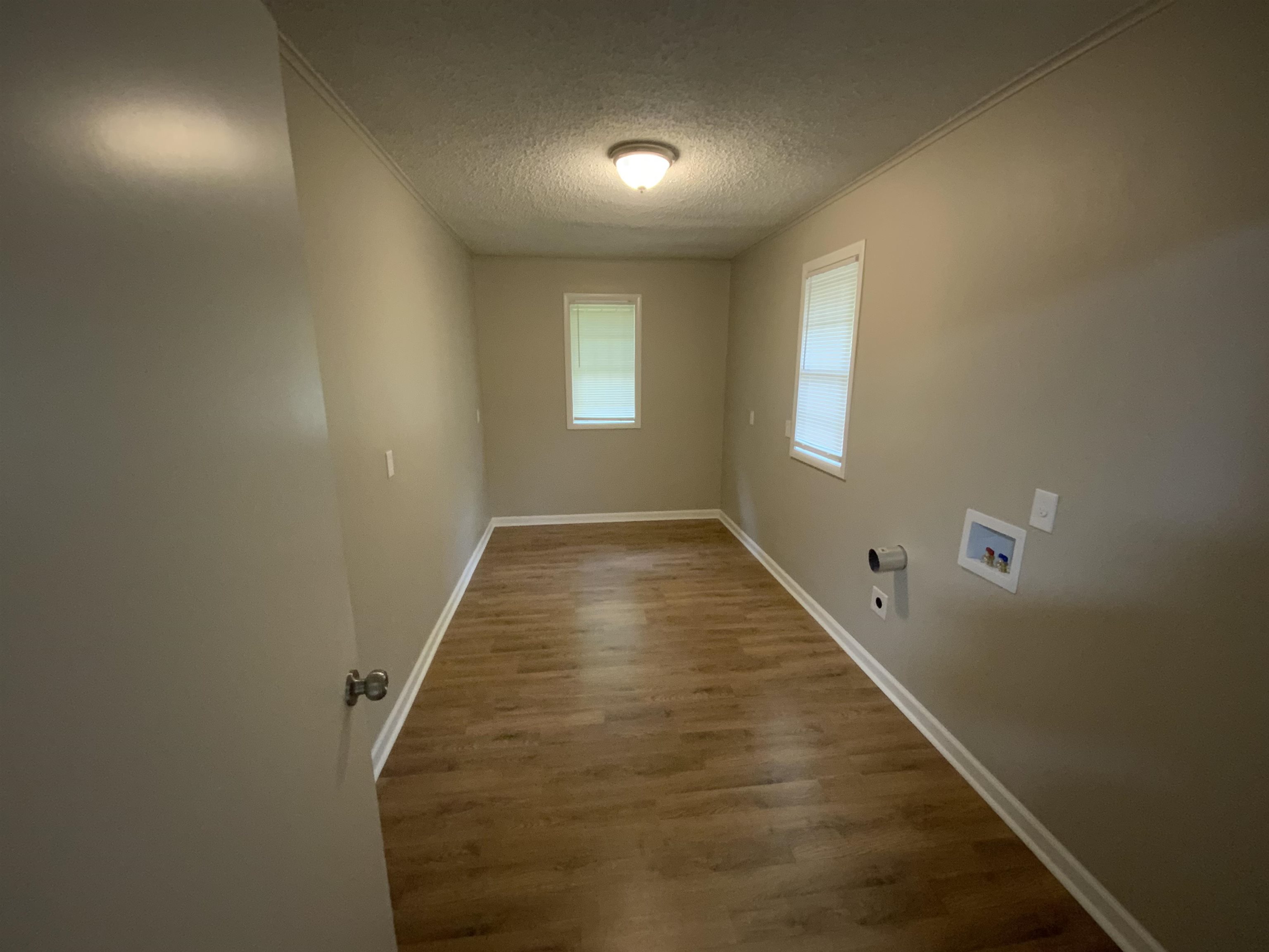 2686 James Road Memphis, TN 38127 - Photo 8 of 19 Laundry room with laundry area, wood finished floors, baseboards, washer hookup, and a textured ceiling