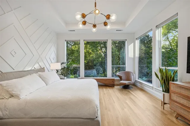 a bedroom with a bed and large windows