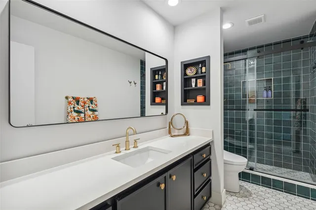 a bathroom with a sink mirror toilet and shower