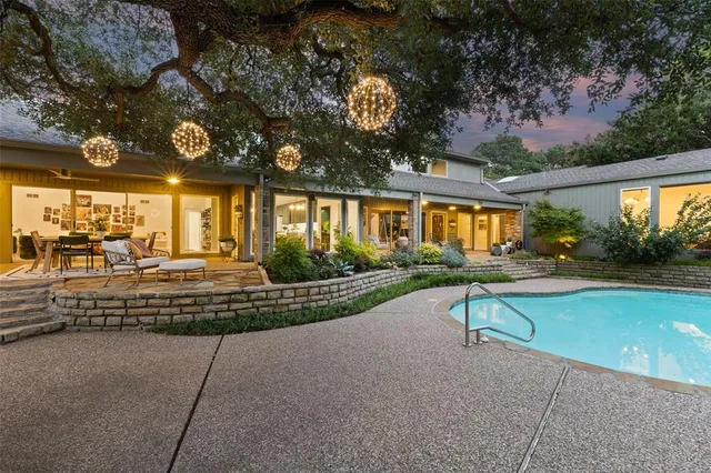 a view of a patio with table and chairs potted plants and large tree