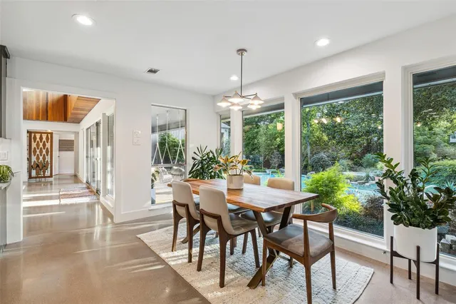 a dining room with furniture a chandelier and wooden floor