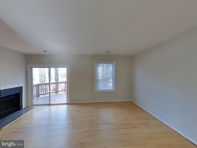 an empty room with windows and fireplace