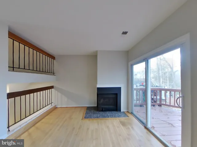 a view of a livingroom with wooden floor and staircase