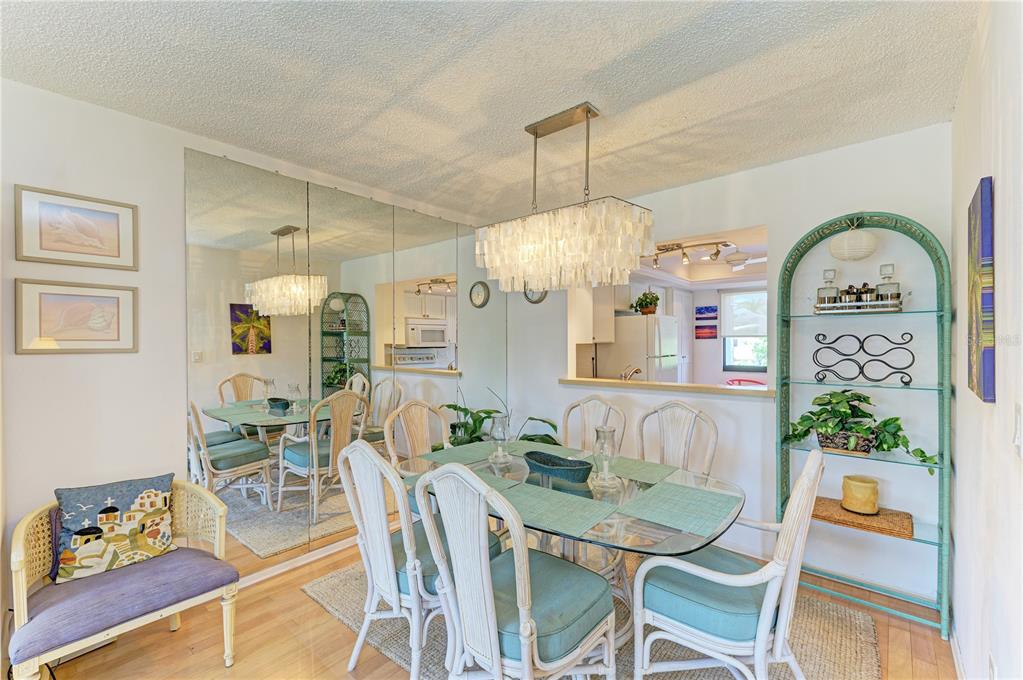6840 Midnight Pass Road, Unit 6840 Sarasota, FL 34242 - Photo 13 of 66 a view of a dining room with furniture window and wooden floor