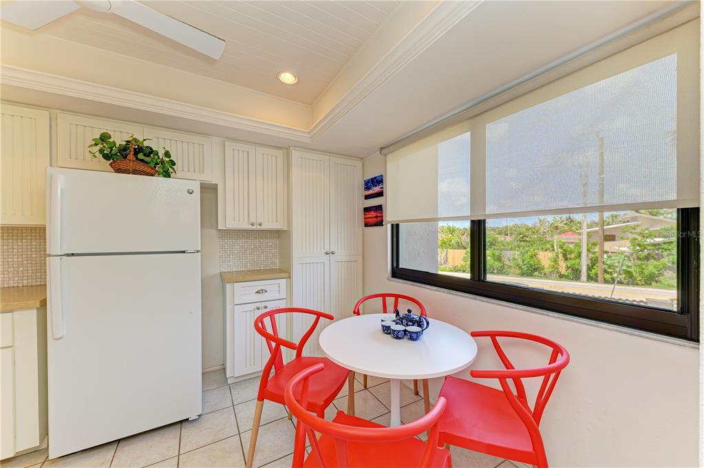 6840 Midnight Pass Road, Unit 6840 Sarasota, FL 34242 - Photo 17 of 66 a table with chairs and a refrigerator
