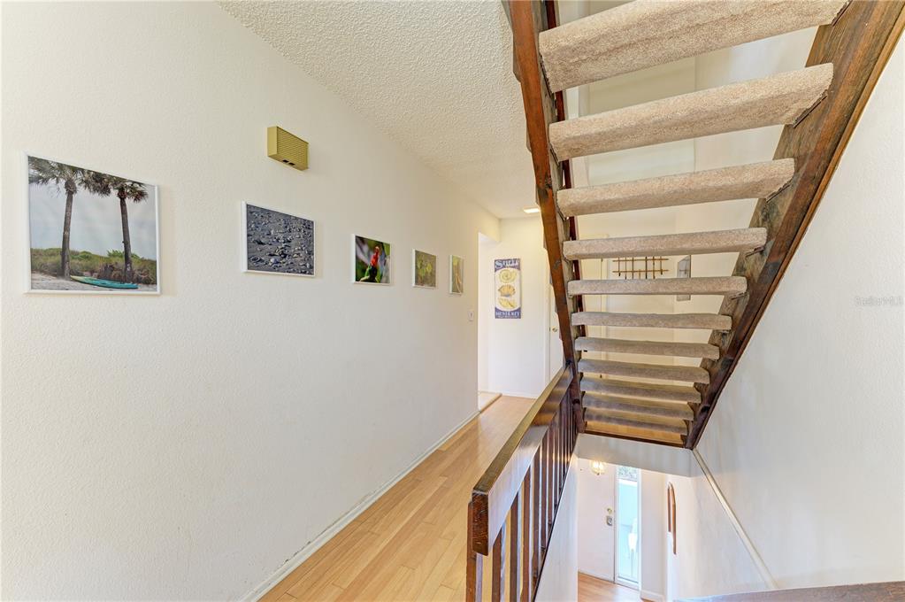 6840 Midnight Pass Road, Unit 6840 Sarasota, FL 34242 - Photo 21 of 66 a view of staircase with wooden floor and white walls