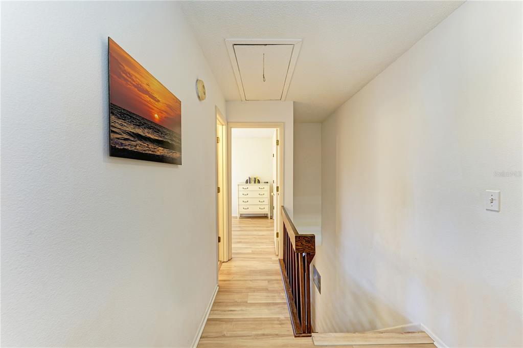 6840 Midnight Pass Road, Unit 6840 Sarasota, FL 34242 - Photo 22 of 66 a view of a hallway with wooden floor and a living room