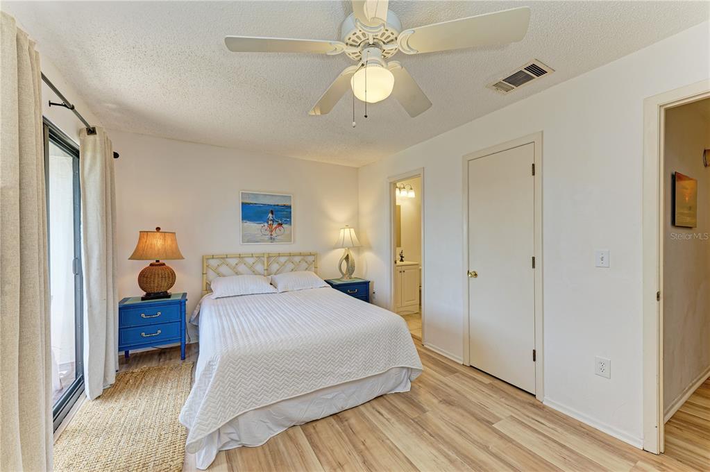 6840 Midnight Pass Road, Unit 6840 Sarasota, FL 34242 - Photo 35 of 66 a bedroom with a bed and a chandelier