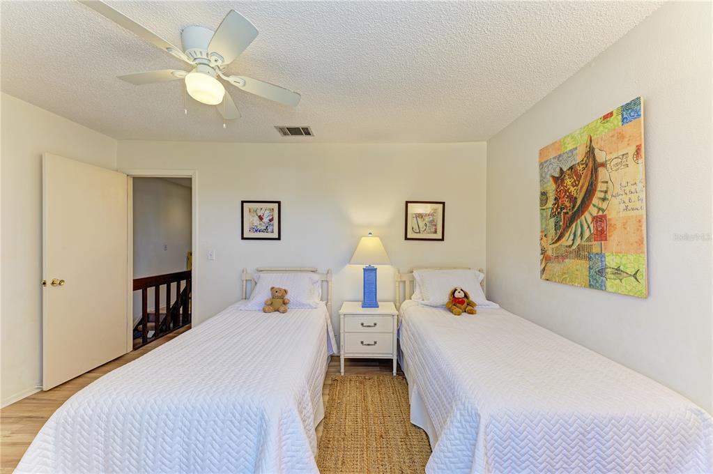 6840 Midnight Pass Road, Unit 6840 Sarasota, FL 34242 - Photo 50 of 66 a bedroom with a bed and a chandelier