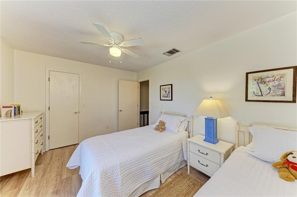 6840 Midnight Pass Road, Unit 6840 Sarasota, FL 34242 - Photo 51 of 66 a bedroom with a bed and a chandelier