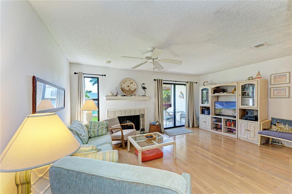 6840 Midnight Pass Road, Unit 6840 Sarasota, FL 34242 - Photo 7 of 66 a living room with furniture and a fireplace