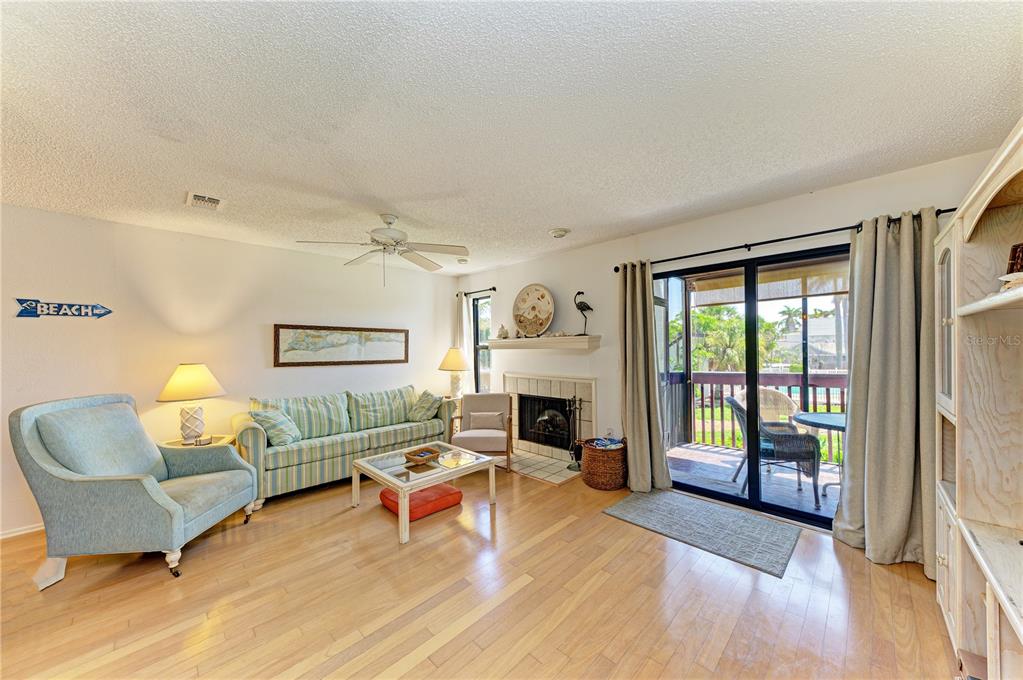 6840 Midnight Pass Road, Unit 6840 Sarasota, FL 34242 - Photo 8 of 66 a living room with furniture and a fireplace