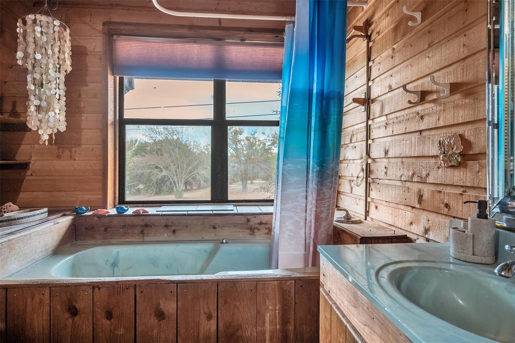 159 Catfish Trail Whitney, TX 76692 - Photo 17 of 36 a bathroom with a granite countertop sink and a large mirror