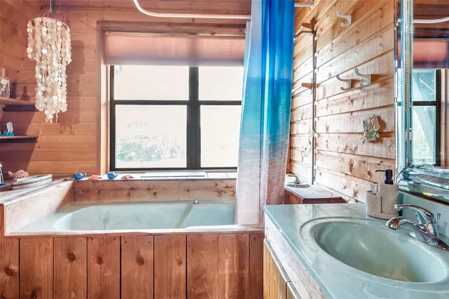 a bathroom with a granite countertop sink and a large window