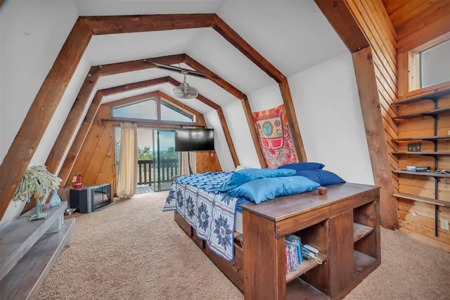 a view of a bedroom with a bed and a window