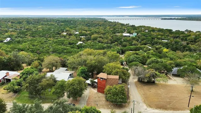 an aerial view of residential houses with outdoor space and trees