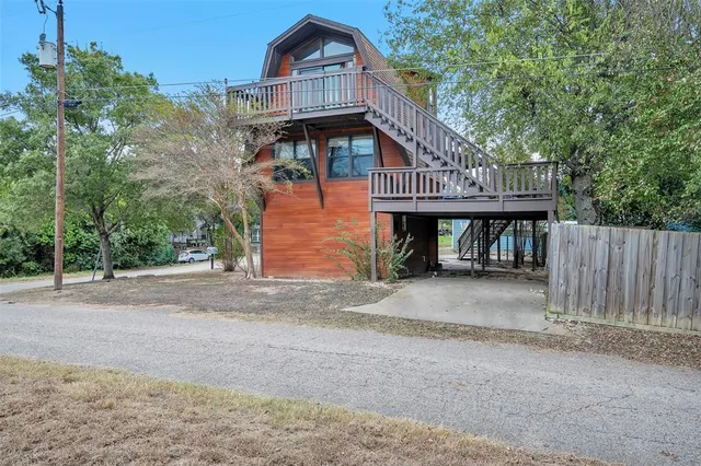 a view of a house with wooden fence next to a road