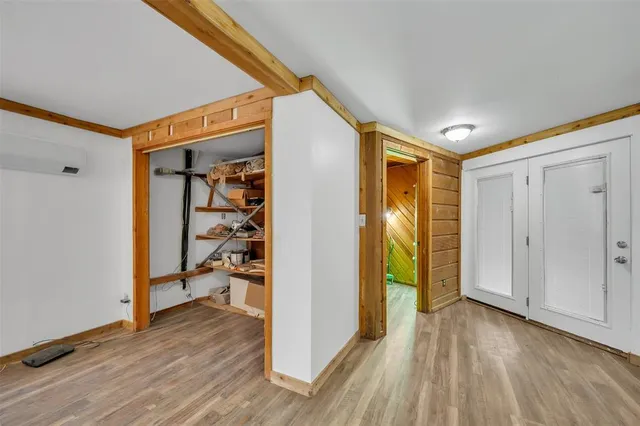 a view of a hallway with wooden floor and dining room