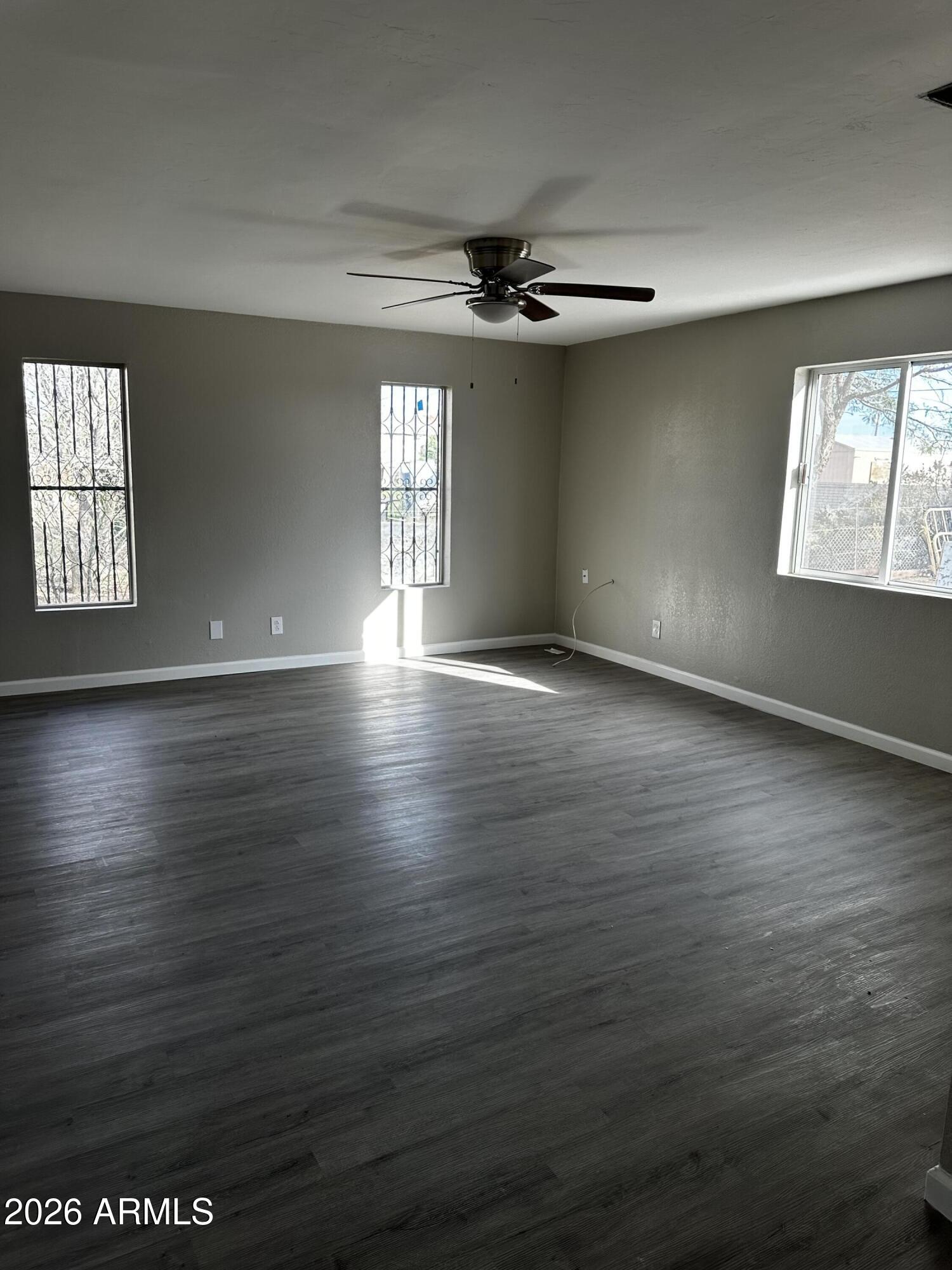 217 East 21st Street Douglas, AZ 85607 - Photo 16 of 22 an empty room with wooden floor chandelier and windows