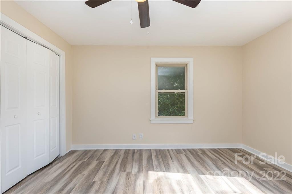 304 West Poplar Street Stanley, NC 28164 - Photo 12 of 21 an empty room with wooden floor and windows