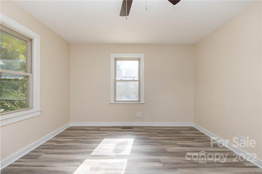 304 West Poplar Street Stanley, NC 28164 - Photo 10 of 21 a view of empty room with wooden floor and fan