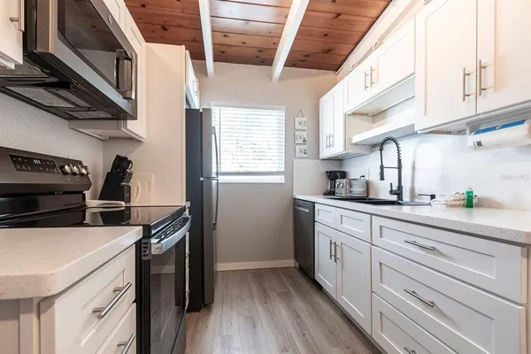 a kitchen with stainless steel appliances a sink a stove and cabinets