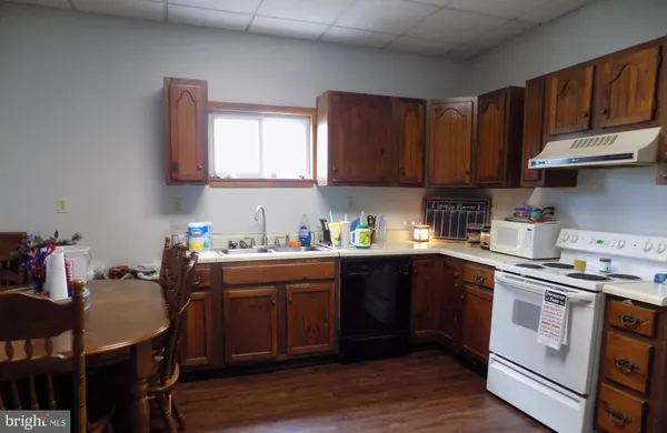 a kitchen with a sink cabinets and wooden floor