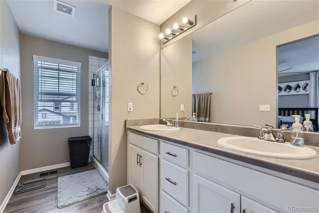 a bathroom with a sink double vanity granite and a mirror