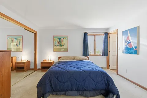 a bedroom with a bed and dresser with mirror