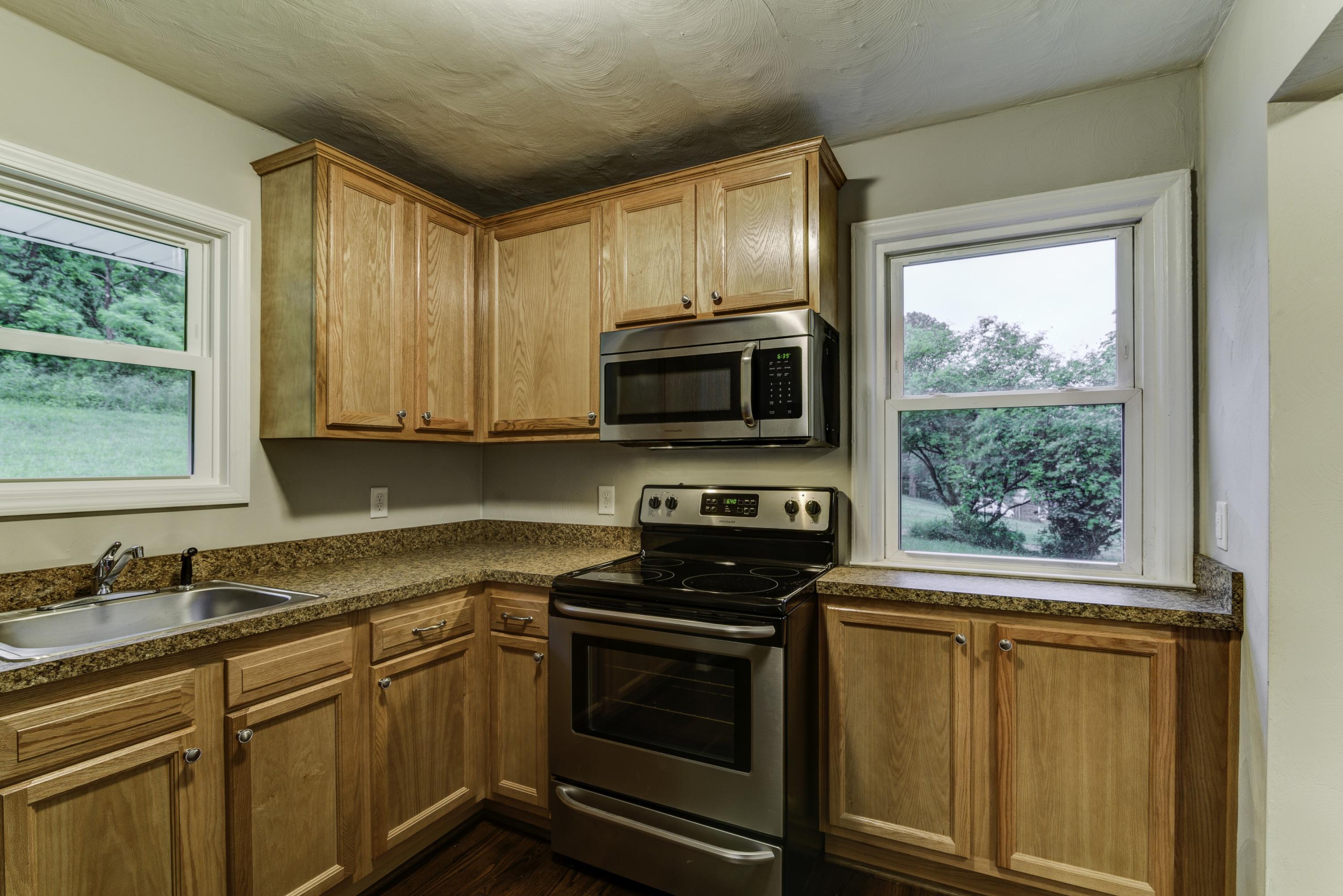 4600 Blue Ridge Boulevard Blue Ridge, VA 24064 - Photo 6 of 27 a kitchen with granite countertop a stove top oven cabinetry a sink and a window