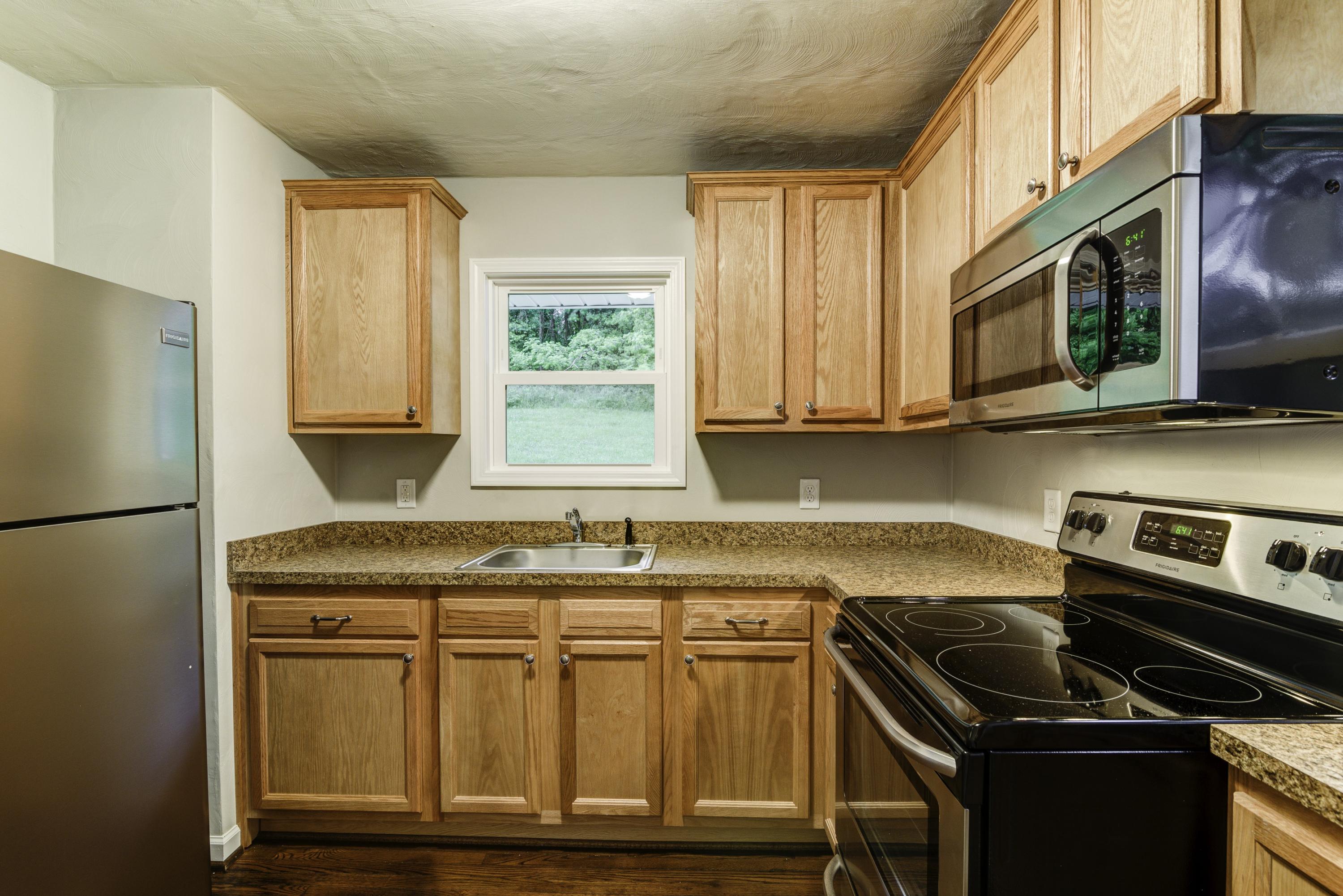 4600 Blue Ridge Boulevard Blue Ridge, VA 24064 - Photo 8 of 27 a kitchen with granite countertop a stove a sink and a refrigerator