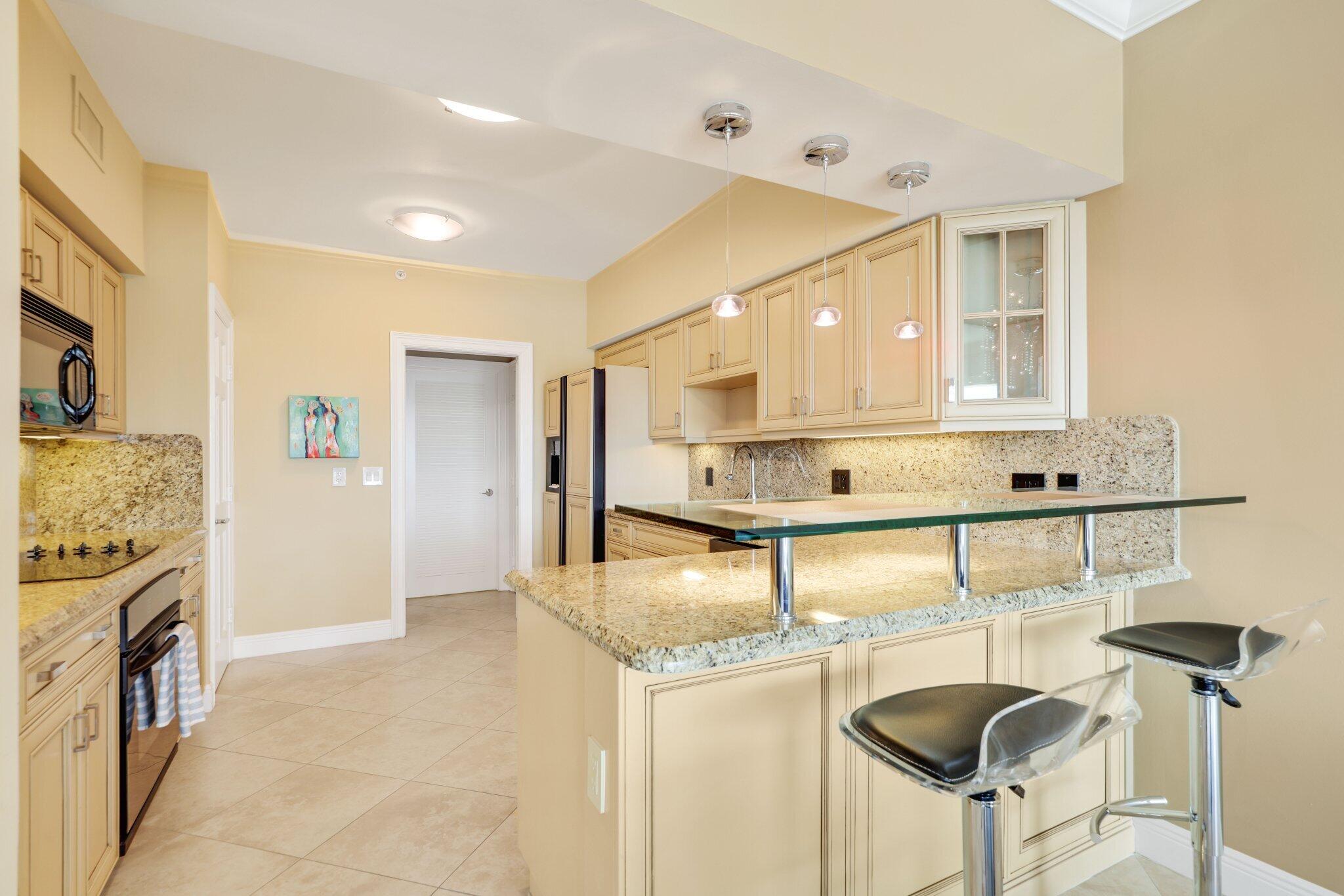 100 Mac Farlane Drive, Unit 3D Delray Beach, FL 33483 - Photo 20 of 57 a view of kitchen with kitchen island stainless steel appliances refrigerator stove microwave and cabinets