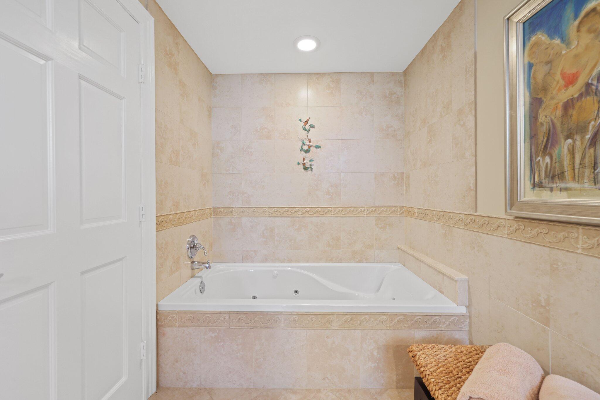 100 Mac Farlane Drive, Unit 3D Delray Beach, FL 33483 - Photo 28 of 57 a bathroom with a bathtub and a shower