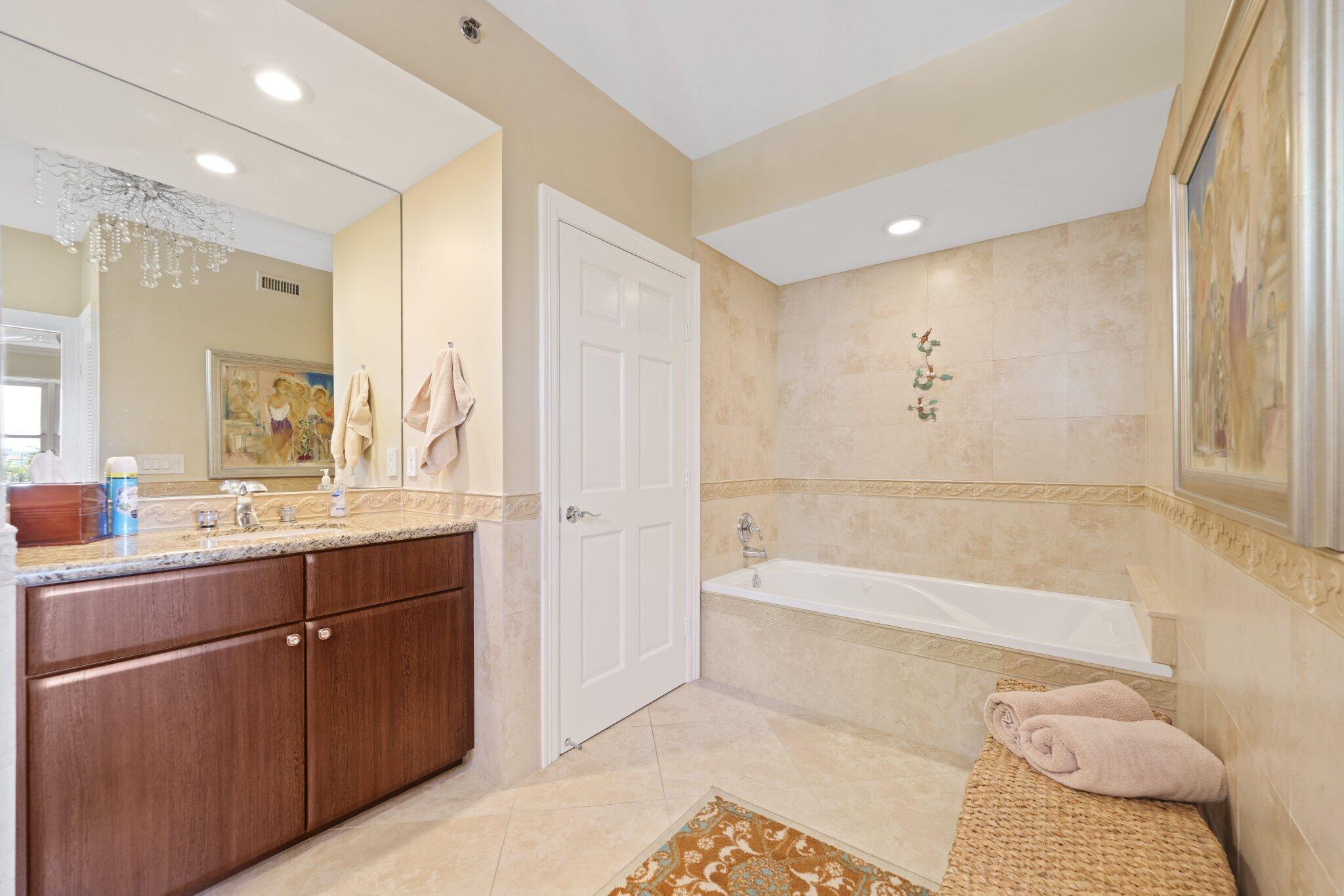 100 Mac Farlane Drive, Unit 3D Delray Beach, FL 33483 - Photo 29 of 57 a spacious bathroom with a tub sink and mirror