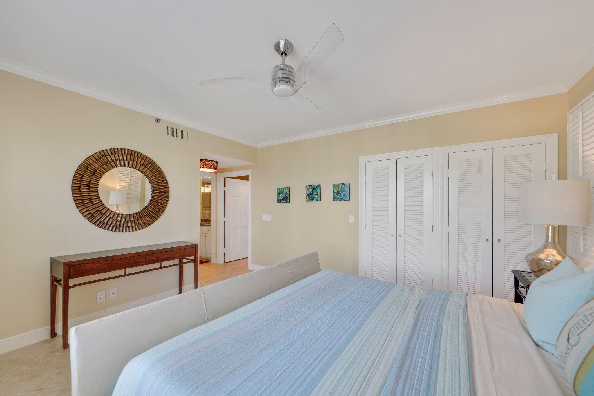 100 Mac Farlane Drive, Unit 3D Delray Beach, FL 33483 - Photo 34 of 57 a bedroom with a bed and a chandelier