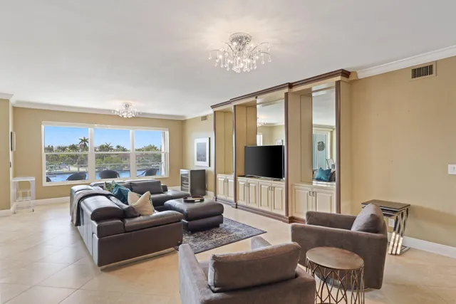 a living room with furniture kitchen view and a window