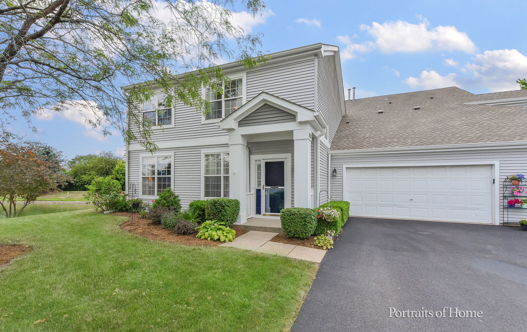 a front view of a house with a garden and plants