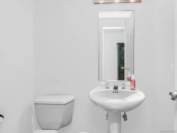 a bathroom with a toilet a sink and a mirror