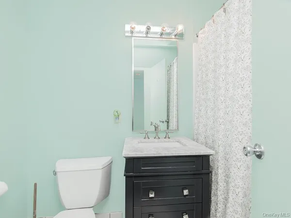 a bathroom with a sink a toilet and a mirror