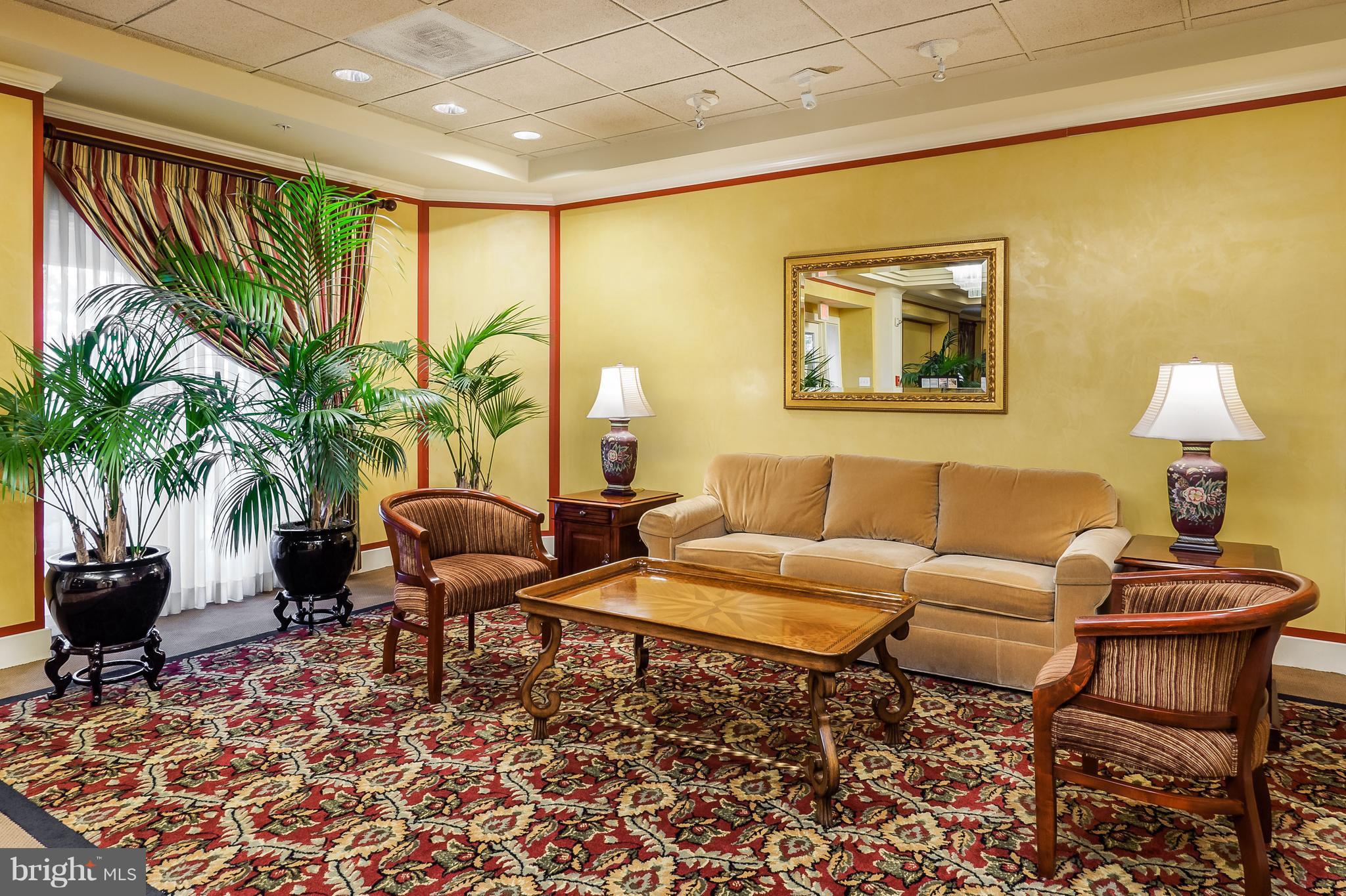19355 Cypress Ridge Terrace, Unit 106 Leesburg, VA 20176 - Photo 1 of 1 a living room with furniture and a potted plant