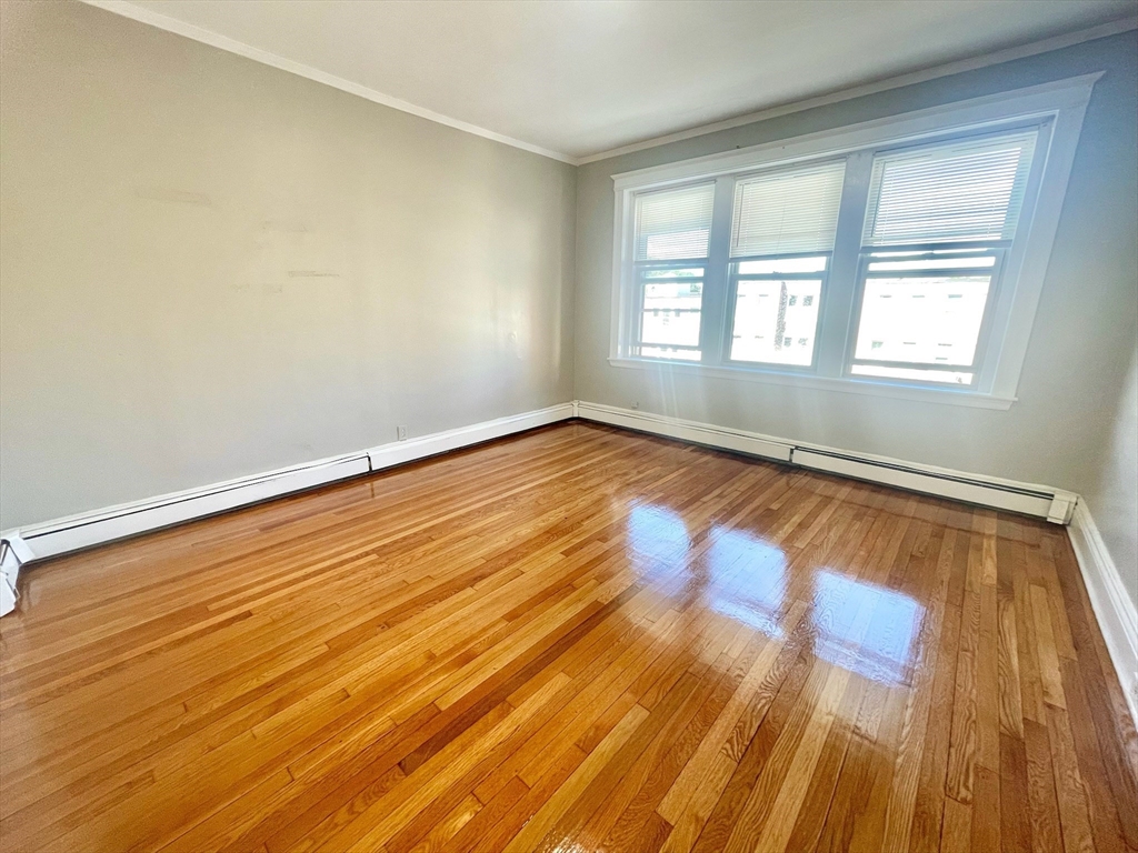 1653 Commonwealth Avenue, Unit 3 Boston, MA 02135 - Photo 11 of 12 an empty room with wooden floor and windows