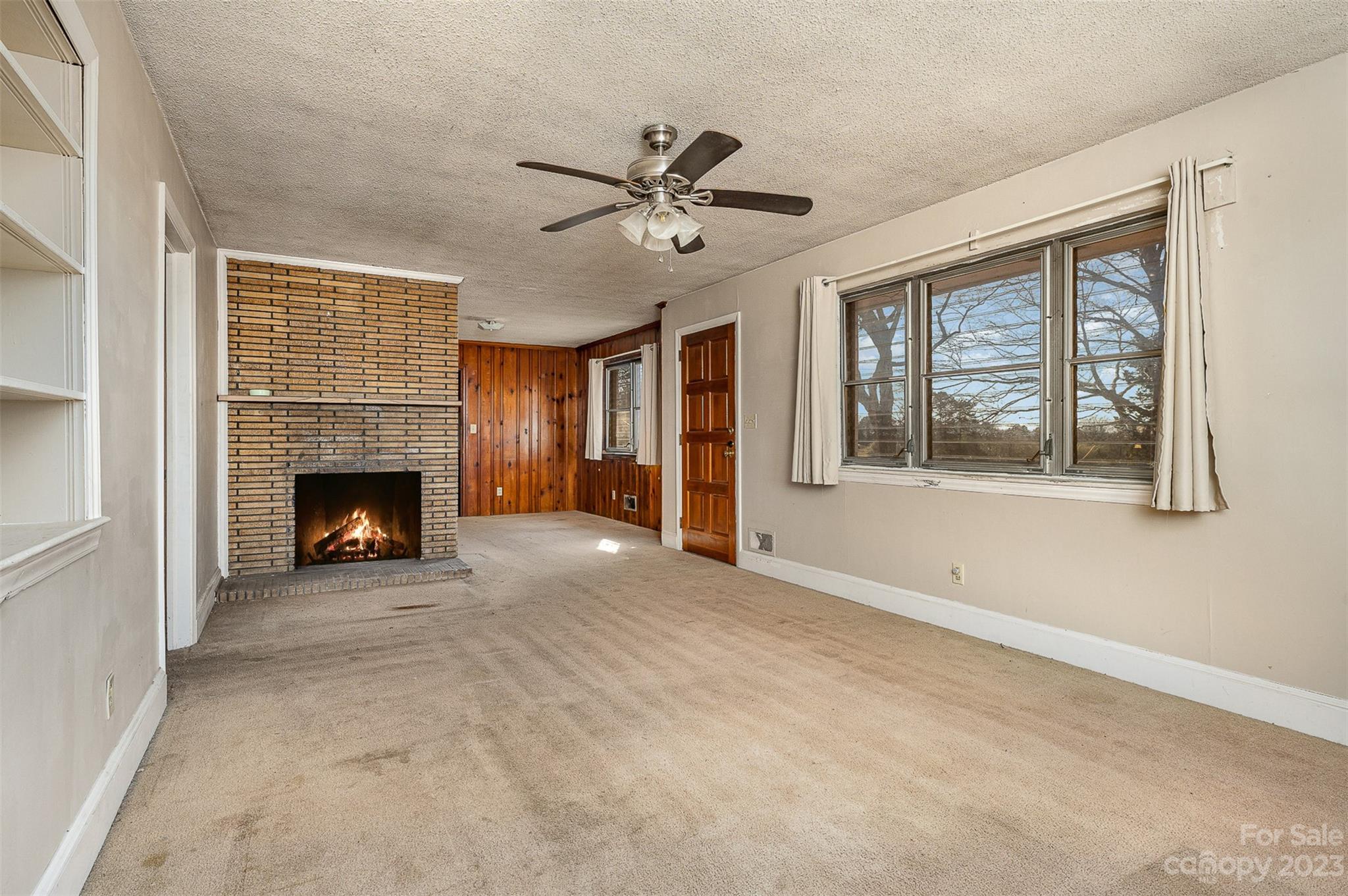 2765 Long Circle Iron Station, NC 28080 - Photo 13 of 26 a view of a livingroom with a fireplace ceiling fan and windows