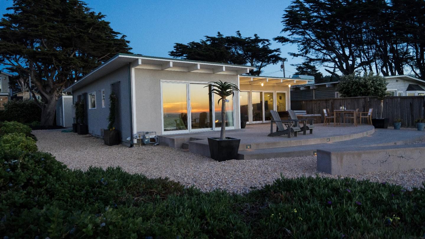 97 Beach Street Moss Beach, CA 94038 - Photo 2 of 43 a view of a patio with table and chairs a barbeque and a large trees