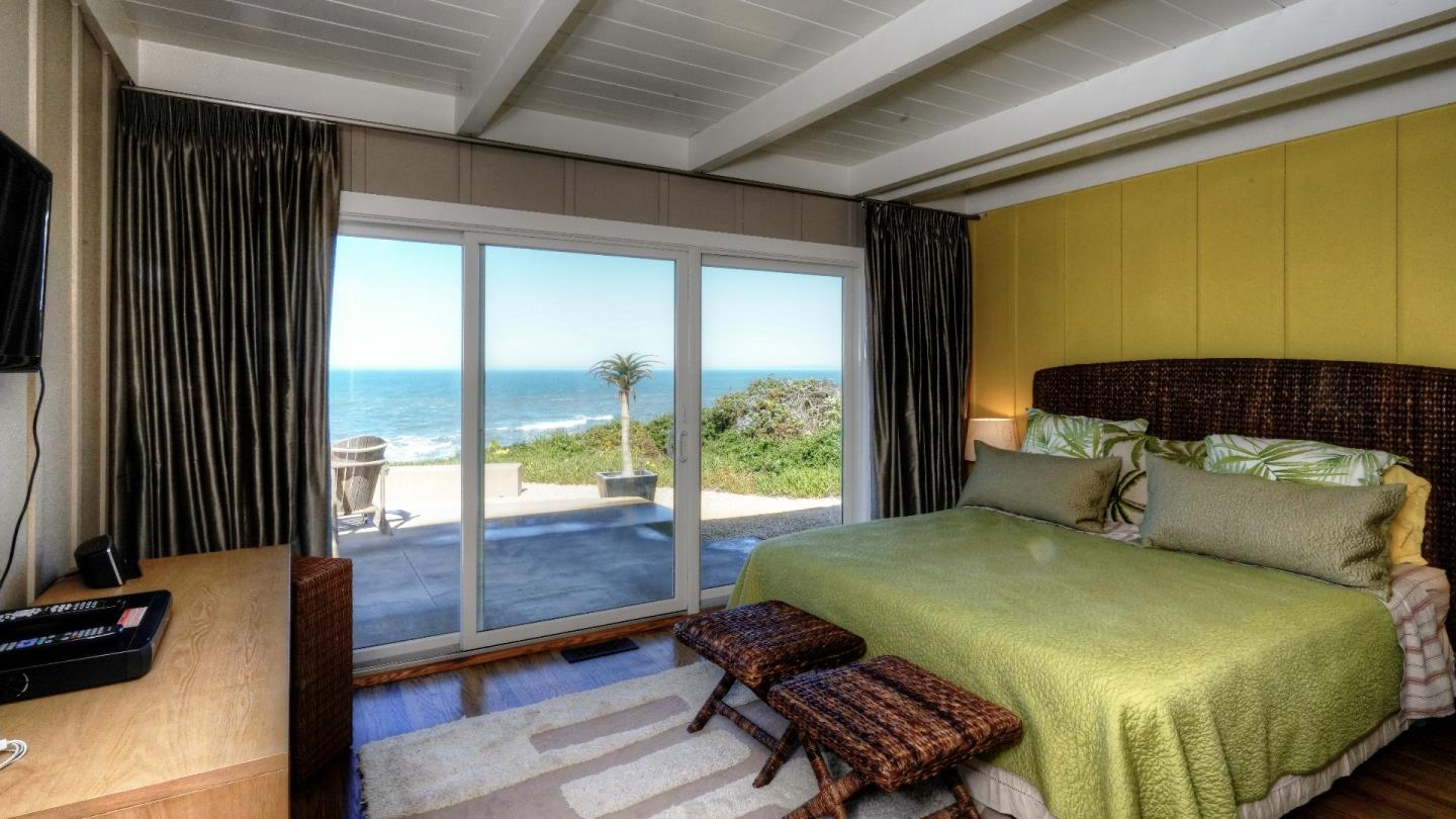 97 Beach Street Moss Beach, CA 94038 - Photo 33 of 43 a bedroom with a bed and large window