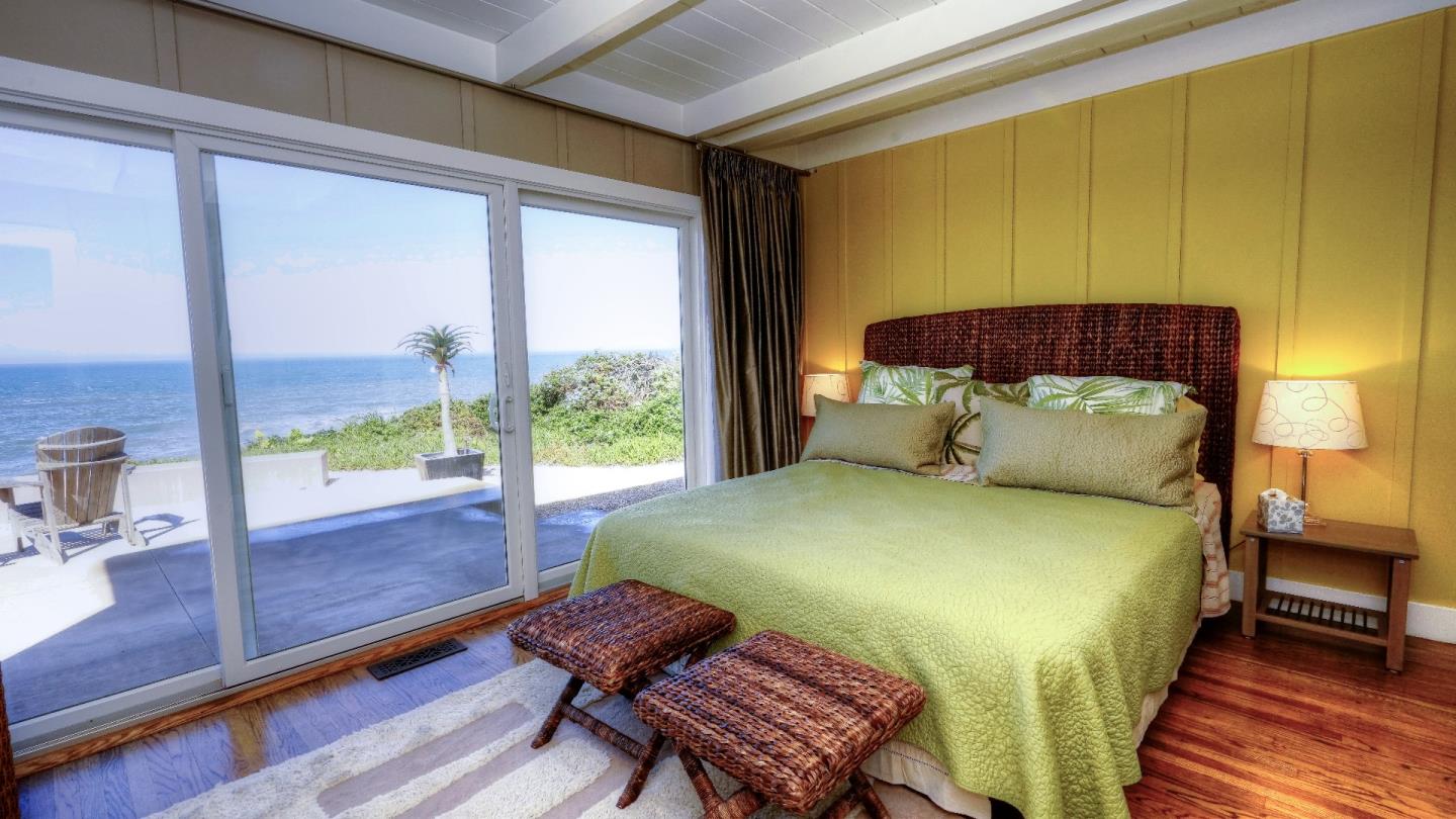97 Beach Street Moss Beach, CA 94038 - Photo 35 of 43 a bedroom with a bed and wooden floor