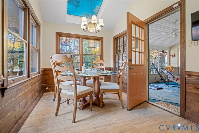 a dining room with furniture a chandelier and wooden floor