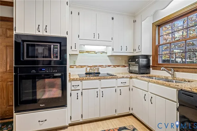 a kitchen with granite countertop white cabinets and window