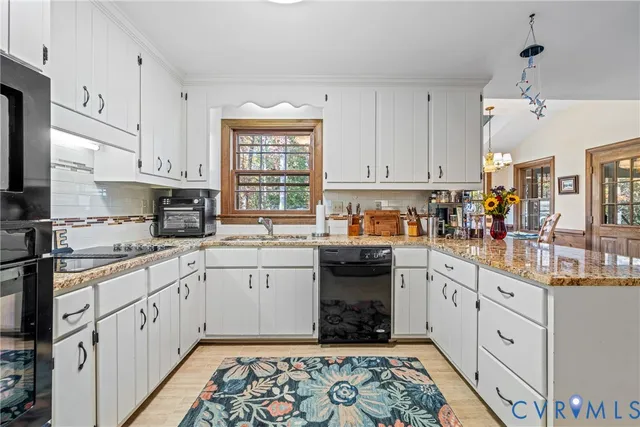 a kitchen with kitchen island granite countertop a sink window and cabinets