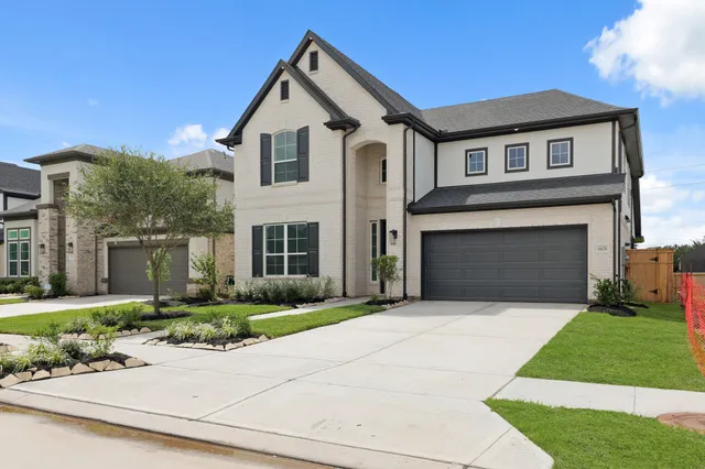 a front view of a house with a garden and garage